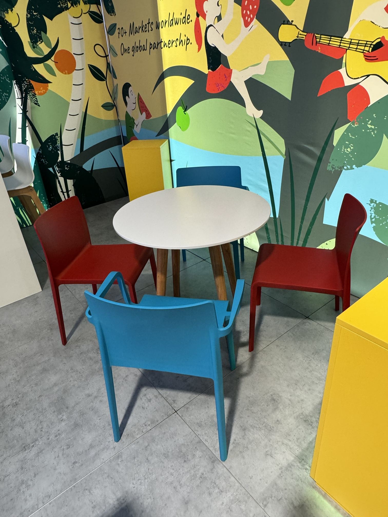 Runder Tisch mit roten und blauen St&uuml;hlen