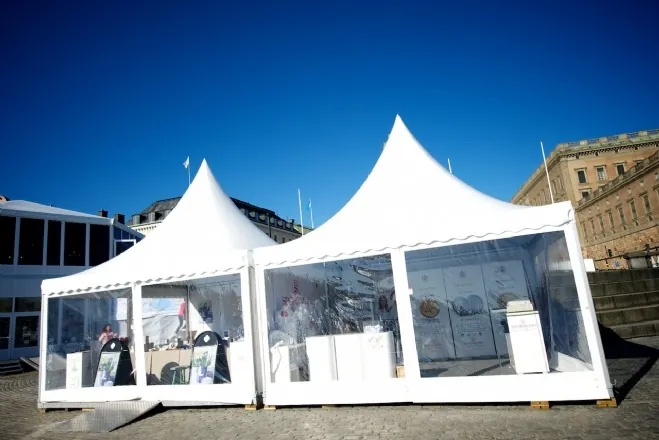 Weiße Pagodenzelte mit transparenten Wänden auf einem Stadtplatz